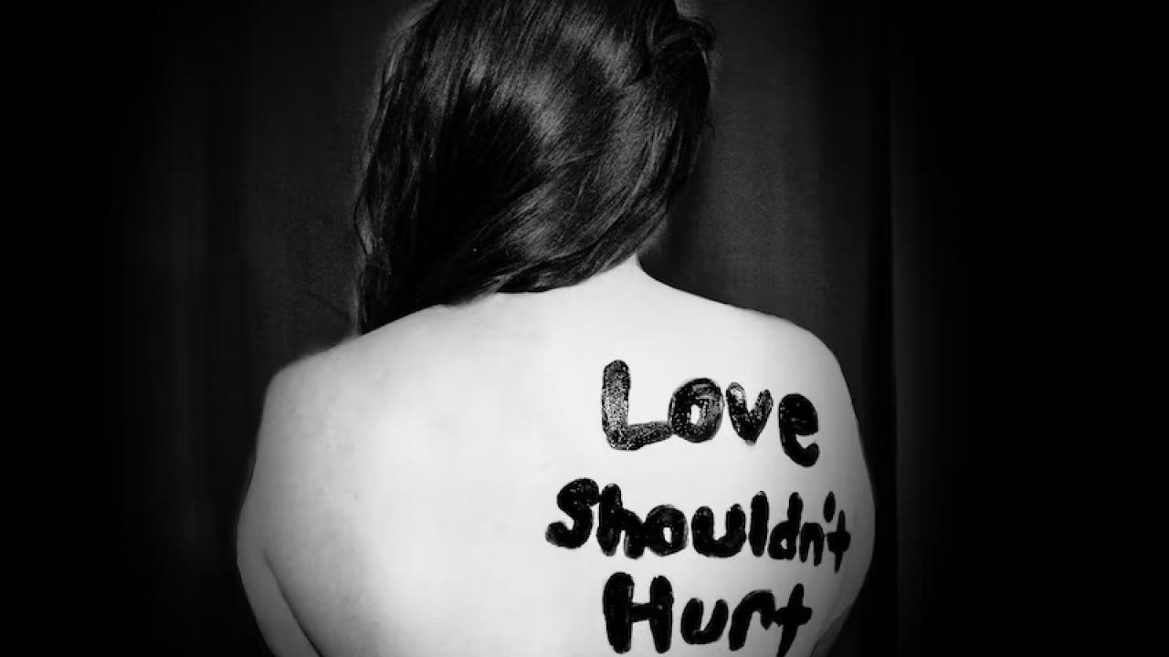 picture of someone with love shouldn't hurt written on them